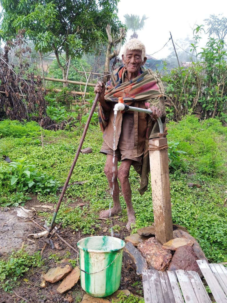 Meshang- a 90-year-old from Nokhu Village under Noklak District collecting potable water from the pipe supplied by JJM under PHED.
